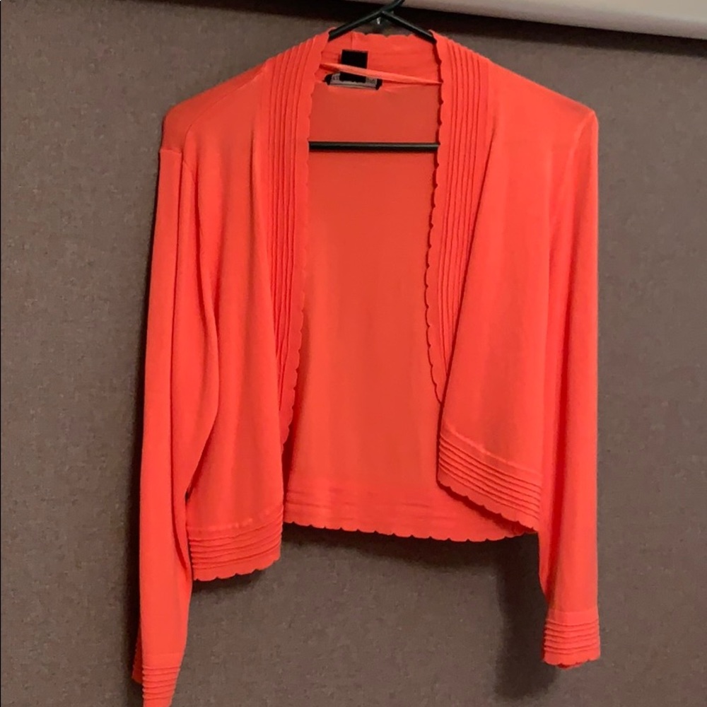 Salmon colored cardigan.